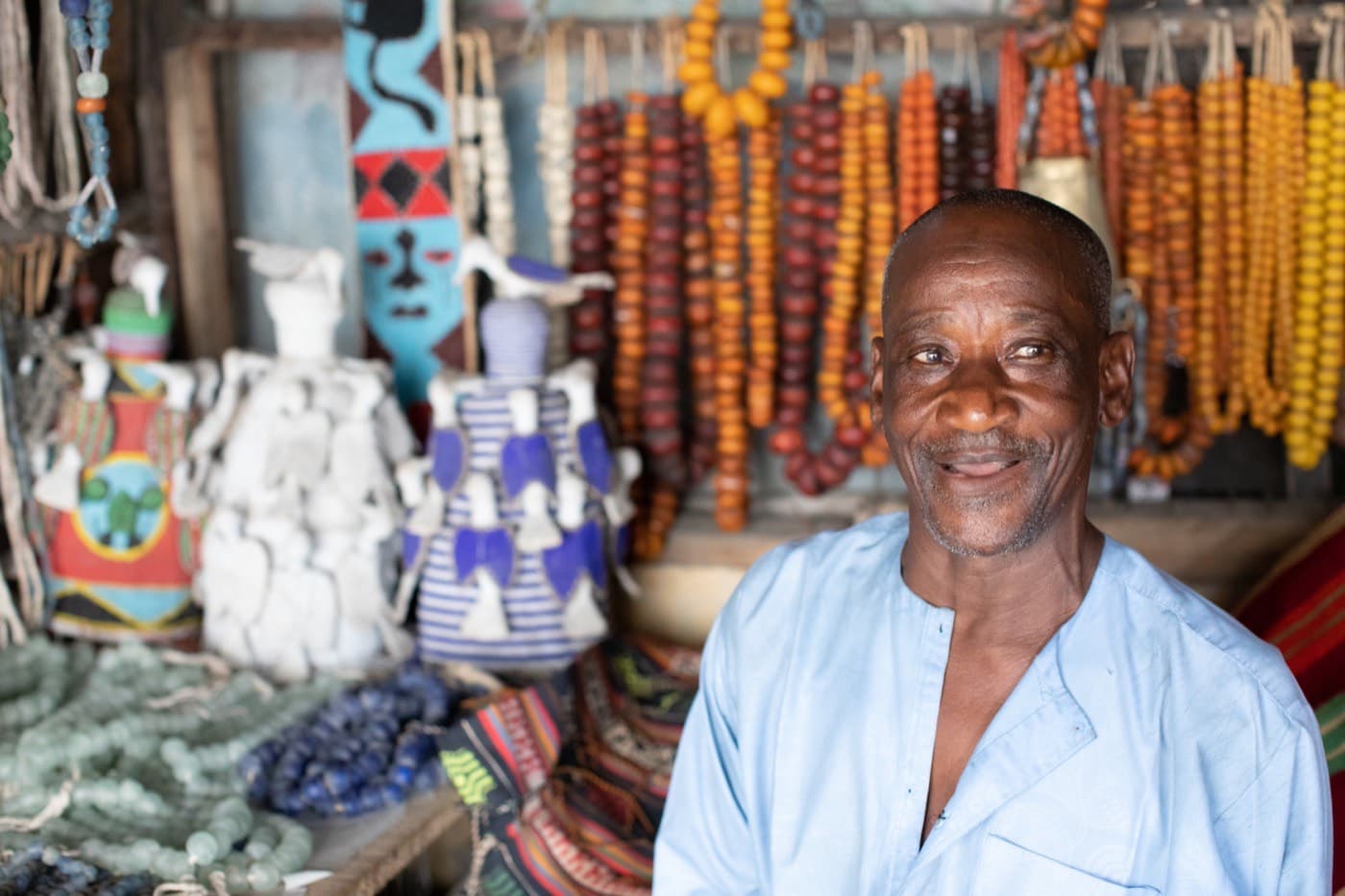 A Nigerian trader standing among the beads and crafts he sells