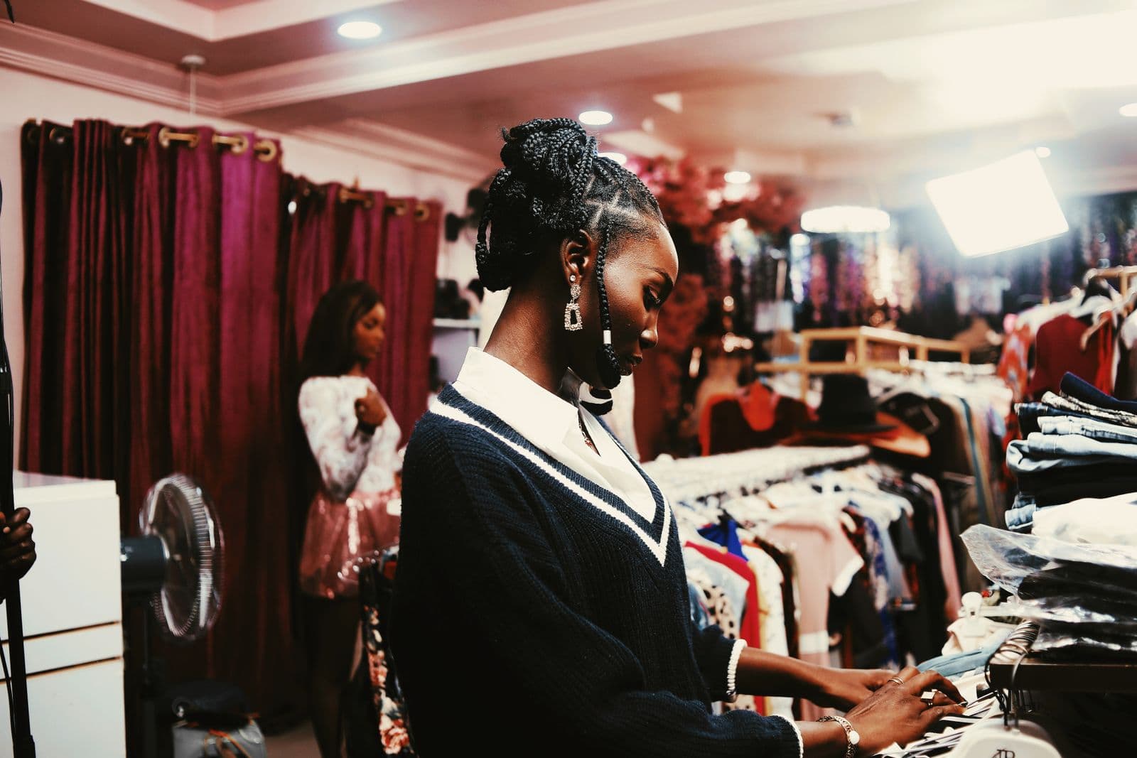 A boutique owner arranging stock in her clothing shop in Abuja